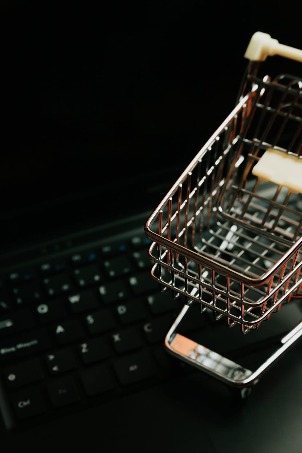 miniature-silver-shopping-cart-on-a-black-keyboard
